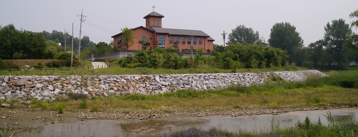 순교자 기념성당 뒤편으로 흐르는 강변에서 바라본 성당 모습.