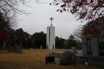 공주 순교자들을 기념하여 2012년 새로 건립한 무덤경당에서 본 12개의 빛돌과 순교탑.