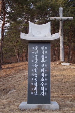 한국 천주교회 최초의 수덕자 홍유한 선생의 묘비. 묘소 뒤에는 대형 십자가가 세워져 있다.