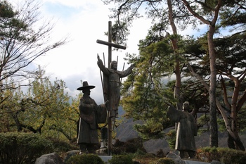 1996년 건립한 부활 예수상과 박상근 마티아 순교복자(우)와 칼래 신부의 우정상이 묘소 뒤에 자리하고 있다.