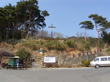 성당 마당에서 뒷산 정상에 조성된 성모동굴로 가는 길. 언덕 위에 대형 십자가가 있고, 조금 올라가면 순교자 오상선의 묘가 있다.